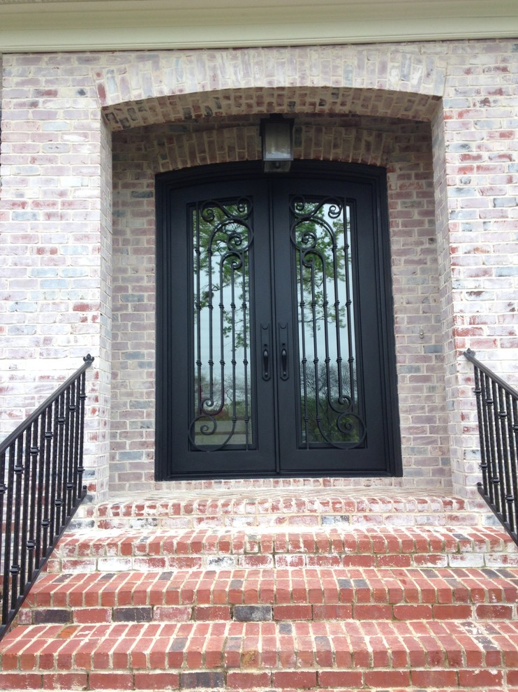На фото: большая входная дверь в стиле неоклассика (современная классика) с двустворчатой входной дверью и металлической входной дверью