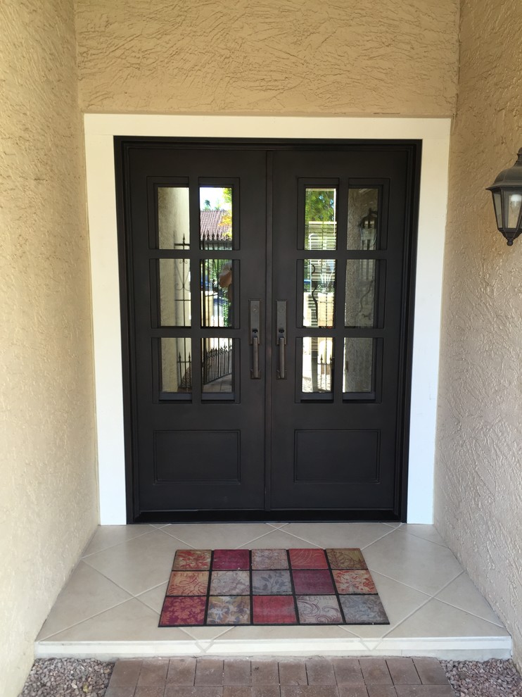 На фото: маленькая входная дверь в стиле фьюжн с разноцветными стенами, полом из керамогранита, двустворчатой входной дверью и черной входной дверью для на участке и в саду с