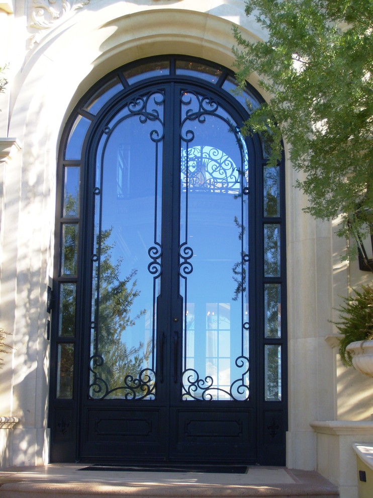 На фото: огромная входная дверь в классическом стиле с белыми стенами, двустворчатой входной дверью и металлической входной дверью