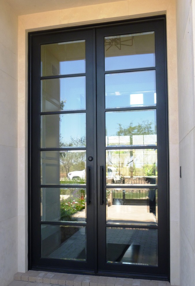 フェニックスにある広いモダンスタイルのおしゃれな玄関ドア (白い壁、金属製ドア) の写真