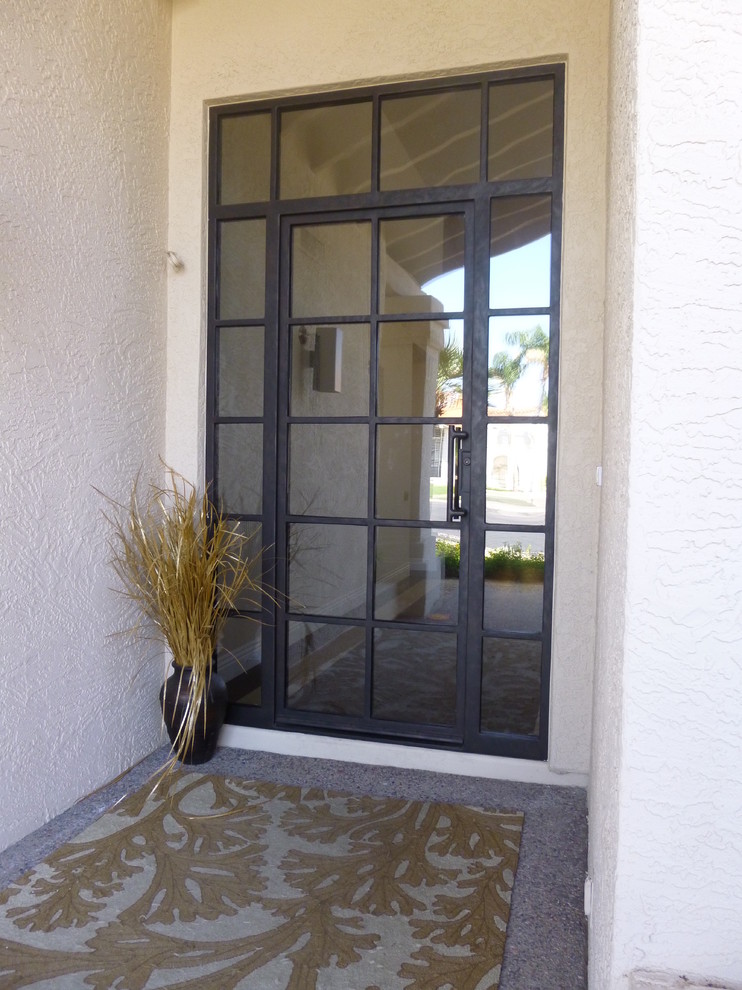 Foto di una grande porta d'ingresso minimalista con pareti bianche, una porta singola e una porta in metallo