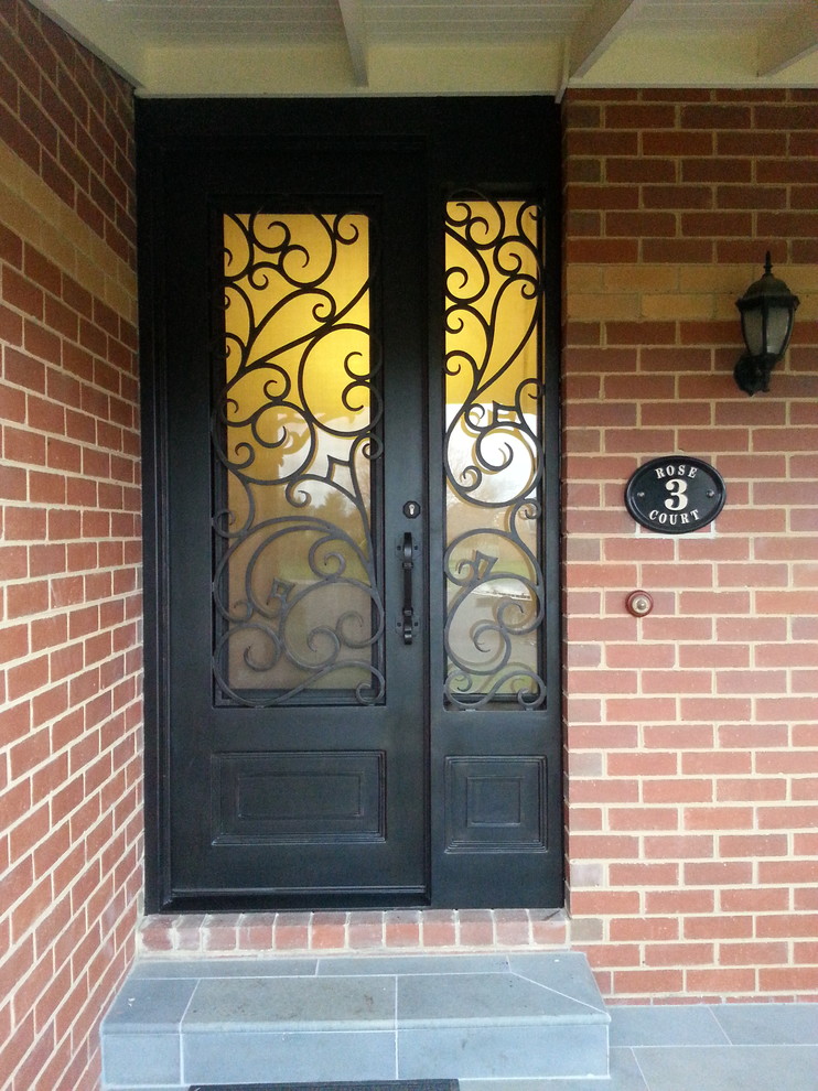 Esempio di una porta d'ingresso con pareti rosse, pavimento in ardesia, una porta singola, una porta in metallo e pavimento grigio
