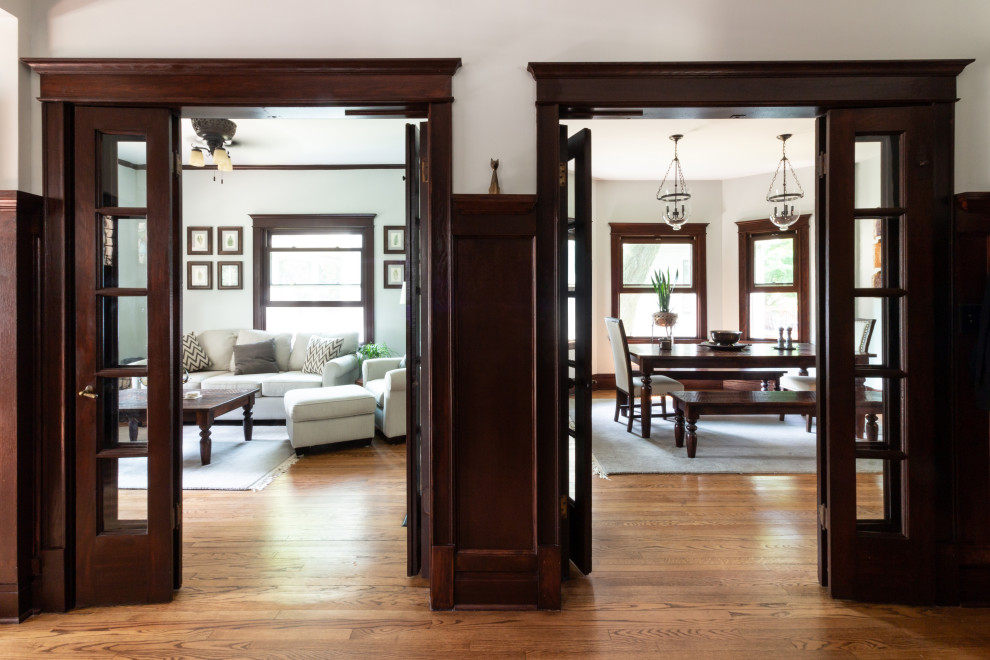 Elegant medium tone wood floor and brown floor foyer photo in Boston with white walls