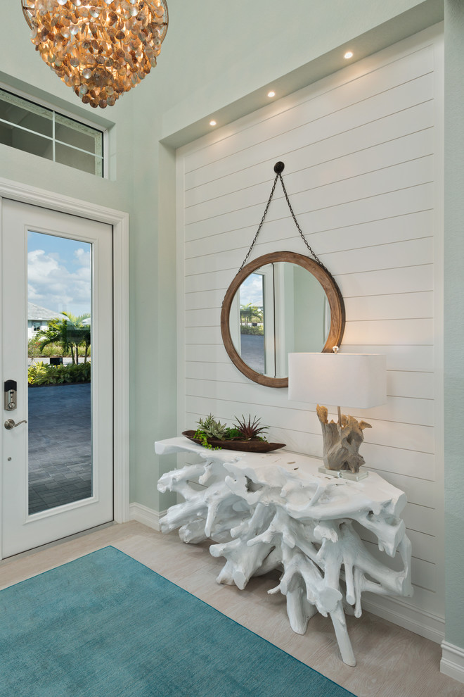 Diseño de entrada marinera con paredes azules, puerta simple, puerta de vidrio y suelo beige