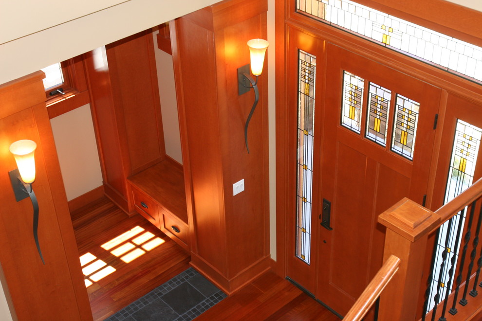 Idee per un ingresso stile americano di medie dimensioni con pareti beige, pavimento in legno massello medio, una porta singola e una porta in legno bruno