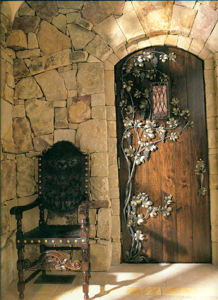 Aménagement d'une entrée méditerranéenne avec une porte en bois foncé.