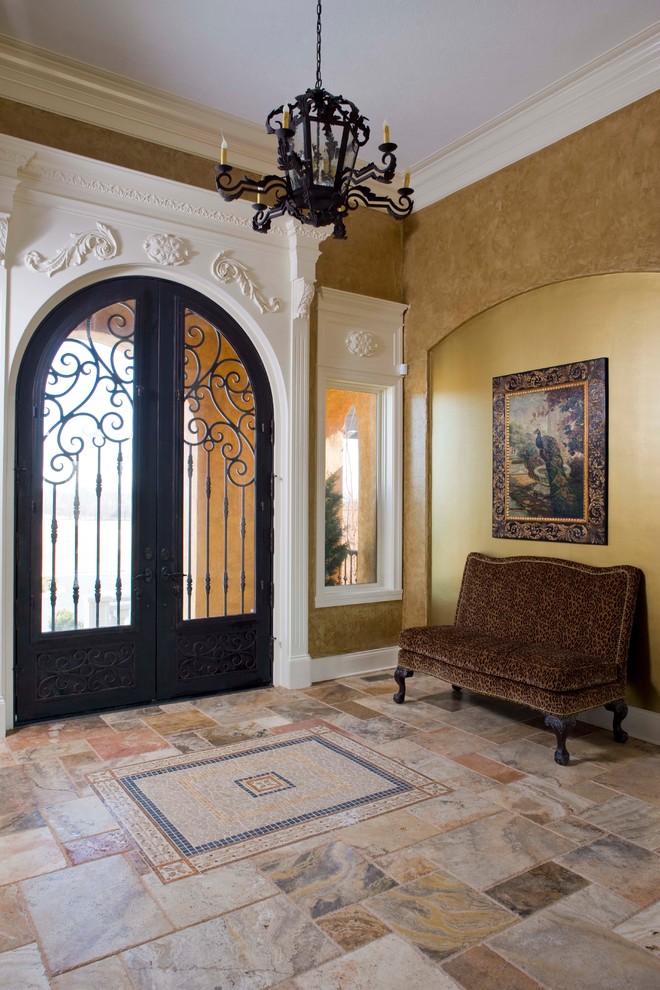 Стильный дизайн: большая входная дверь в средиземноморском стиле с коричневыми стенами, полом из травертина и двустворчатой входной дверью - последний тренд