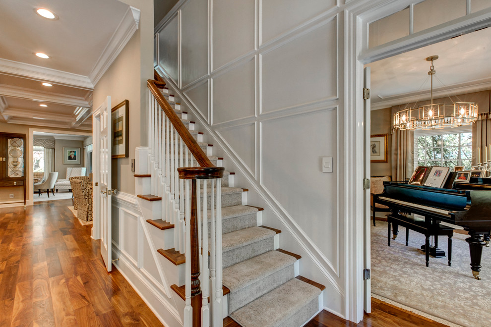 This is an example of a large classic foyer in Raleigh with white walls and dark hardwood flooring.