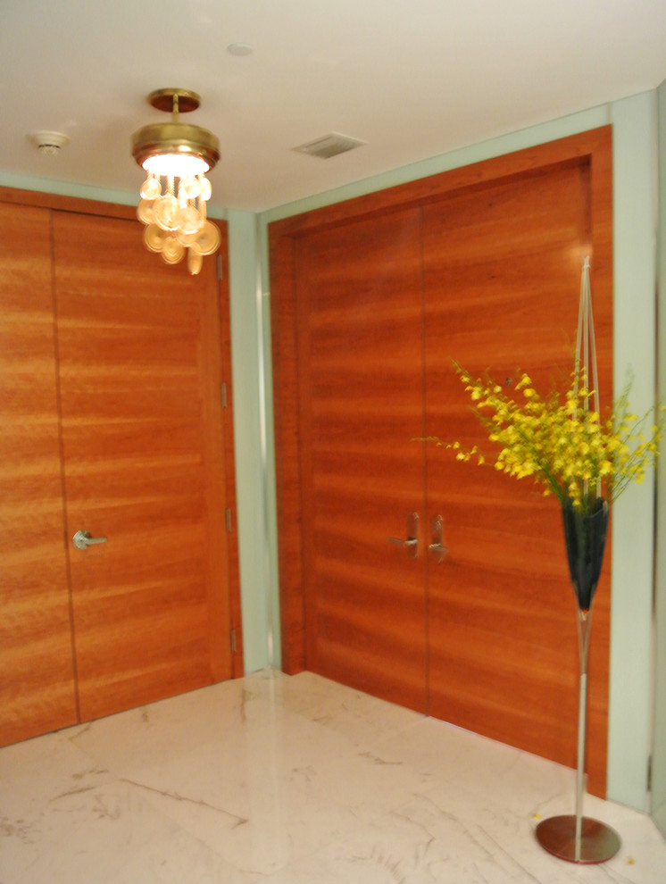 Ejemplo de distribuidor actual de tamaño medio con paredes verdes, suelo de mármol, puerta doble, puerta de madera en tonos medios y suelo multicolor