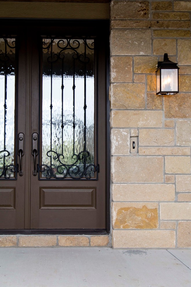 Idee per una porta d'ingresso tradizionale di medie dimensioni con pareti beige, pavimento in cemento, una porta a due ante e una porta marrone