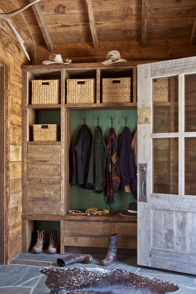 Inspiration for a rustic gray floor mudroom remodel in Other with green walls
