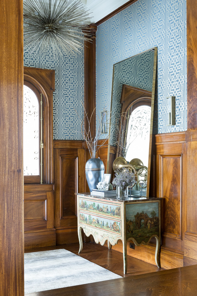 Idée de décoration pour un grand vestibule tradition avec un mur multicolore et parquet foncé.