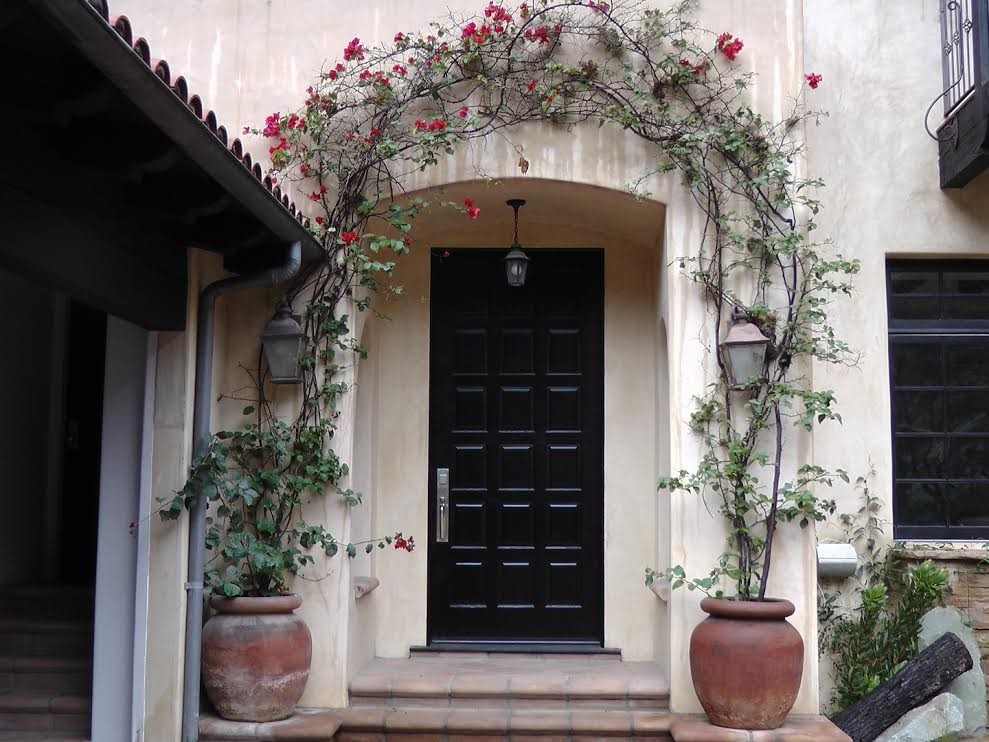 Ispirazione per una porta d'ingresso mediterranea di medie dimensioni con pareti beige, pavimento con piastrelle in ceramica, una porta singola e una porta nera