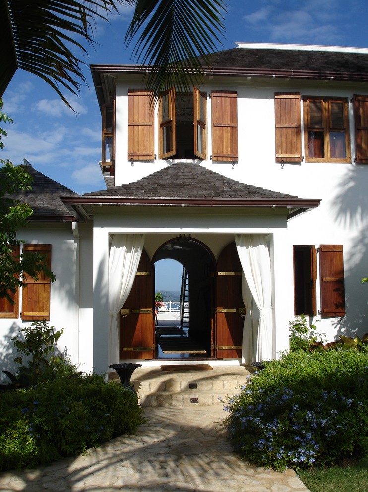 Esempio di una porta d'ingresso tropicale con una porta a due ante e una porta in legno scuro