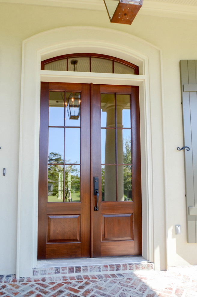 Exemple d'une grande porte d'entrée chic avec un mur blanc, une porte double et une porte en bois brun.
