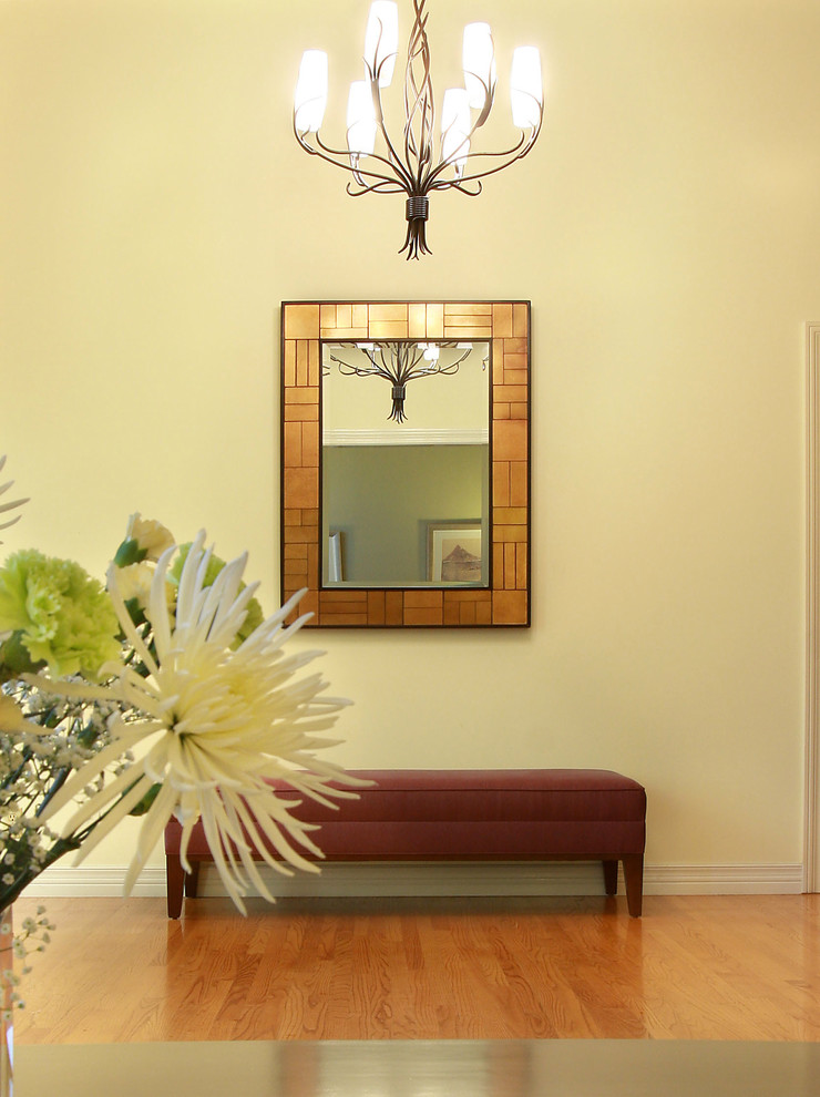 Example of a large eclectic light wood floor entryway design in Los Angeles with beige walls and a white front door