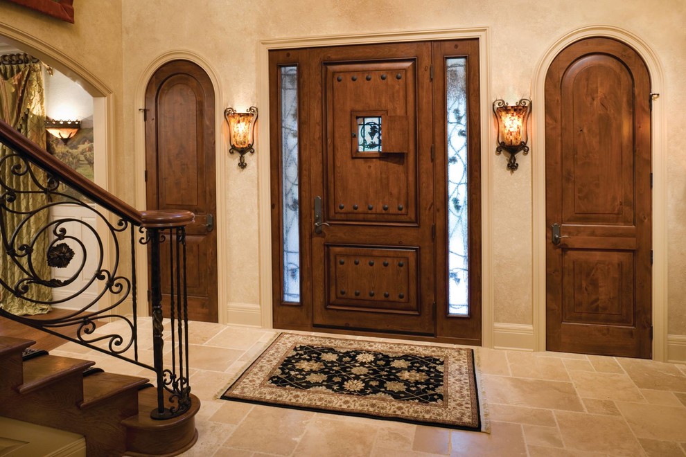 Modelo de puerta principal mediterránea grande con paredes beige, suelo de travertino, puerta simple, puerta de madera oscura y suelo beige