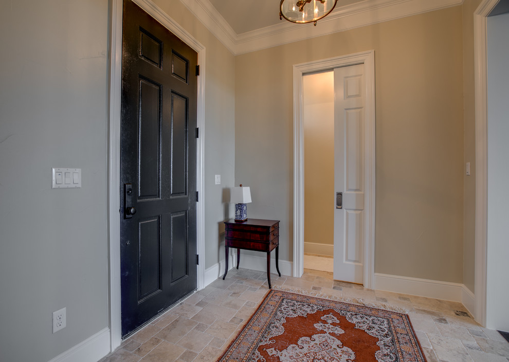 Ispirazione per un ingresso chic di medie dimensioni con pareti beige, pavimento in travertino, una porta singola, una porta nera e pavimento beige