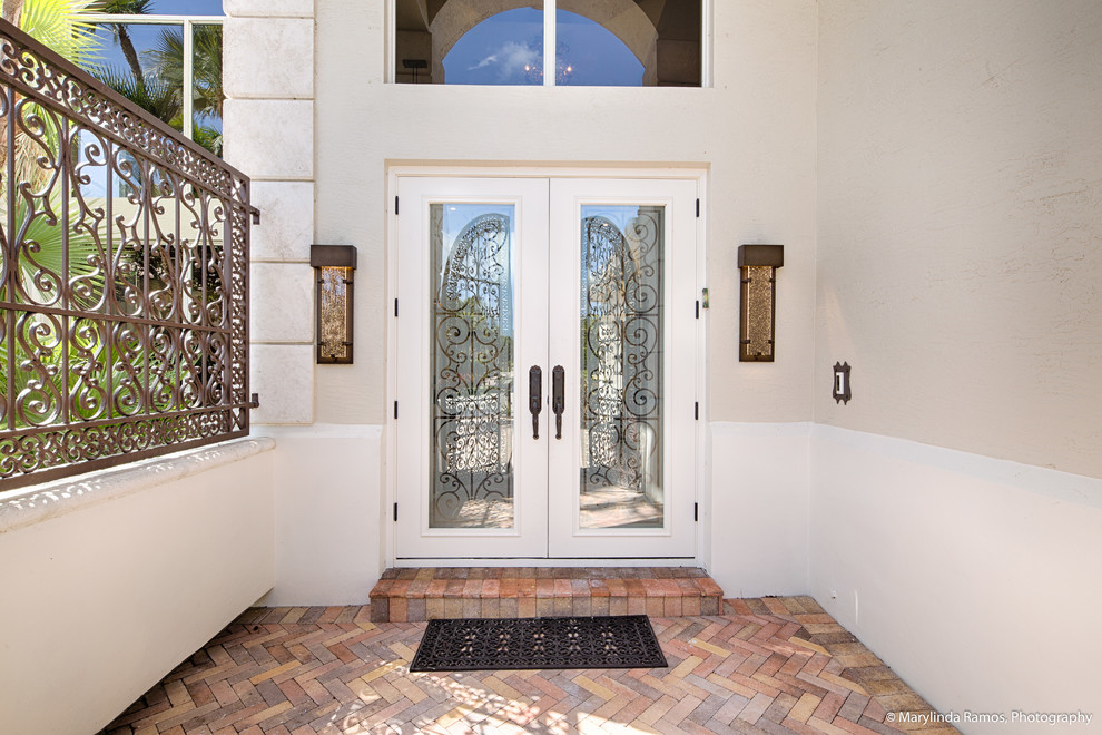 Источник вдохновения для домашнего уюта: входная дверь в средиземноморском стиле с бежевыми стенами, кирпичным полом, двустворчатой входной дверью, стеклянной входной дверью и оранжевым полом