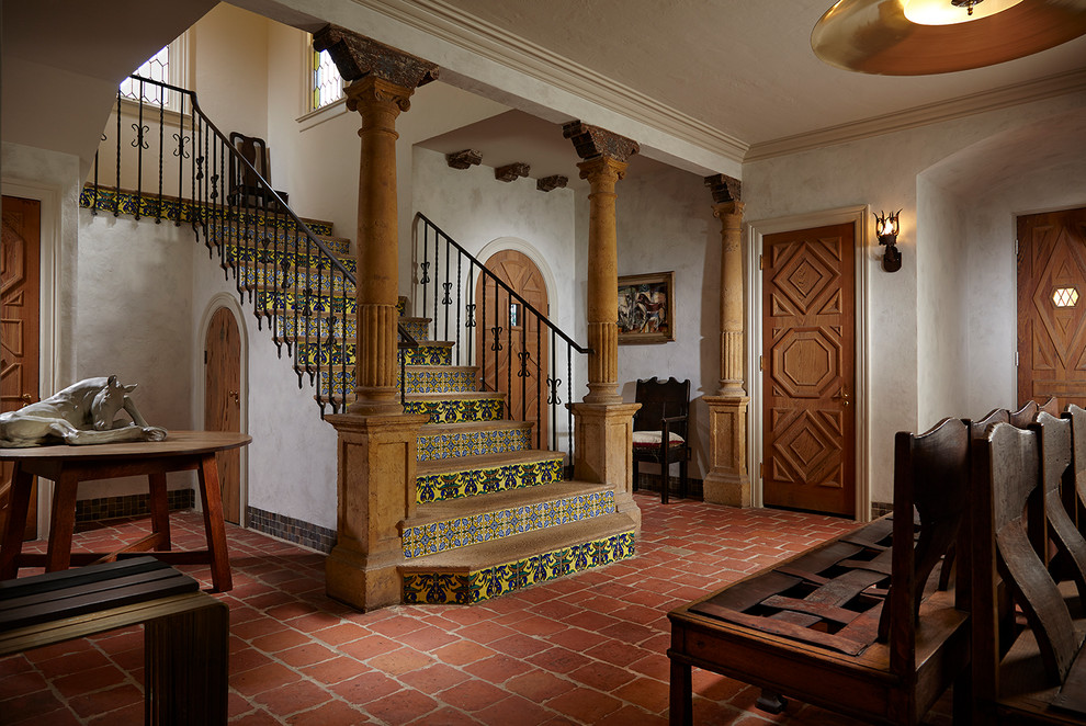 Mediterranes Foyer mit weißer Wandfarbe, Backsteinboden, Einzeltür, hellbrauner Holzhaustür und rotem Boden in Miami