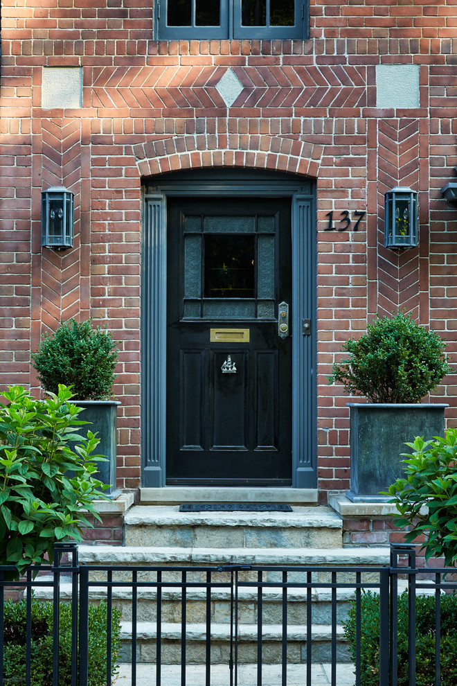 トロントにある高級な小さなトラディショナルスタイルのおしゃれな玄関ドア (赤い壁、黒いドア、グレーの床) の写真