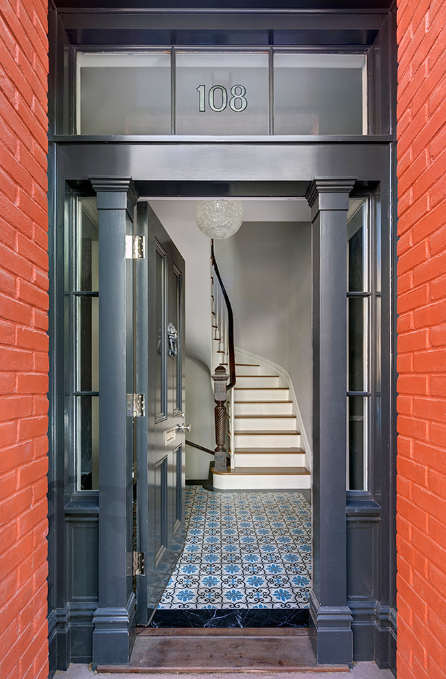 Cette image montre une entrée traditionnelle avec une porte simple et une porte bleue.