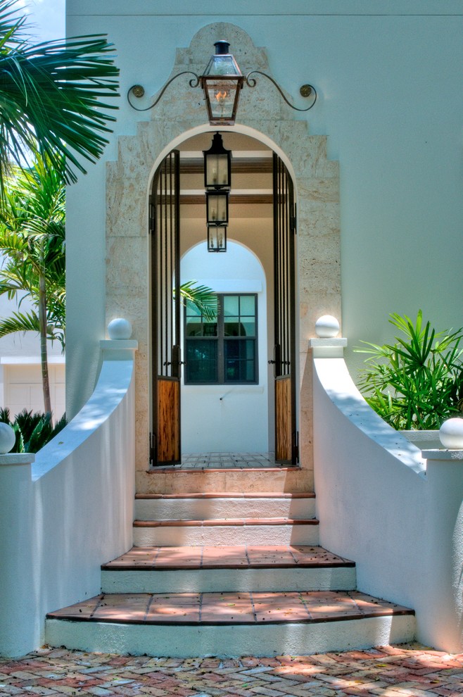 Пример оригинального дизайна: вестибюль среднего размера в средиземноморском стиле с белыми стенами, полом из керамической плитки, одностворчатой входной дверью и входной дверью из дерева среднего тона