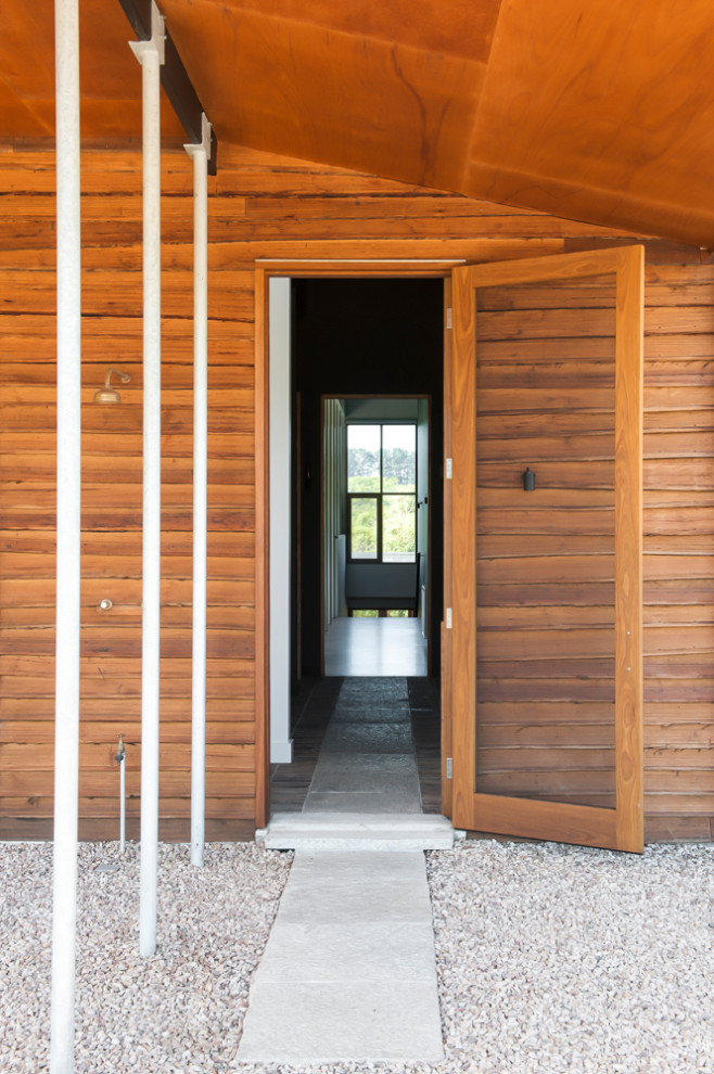 Exemple d'une grande entrée moderne avec un couloir, un mur marron, parquet en bambou, une porte simple, une porte en bois brun et un sol marron.
