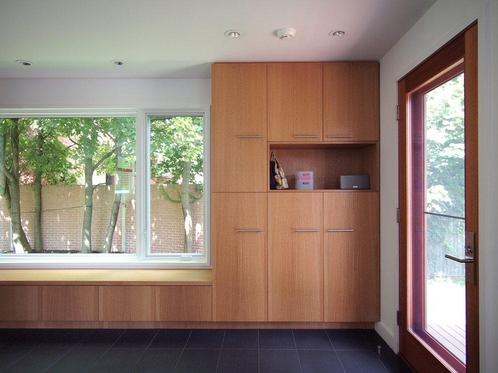 Imagen de vestíbulo posterior minimalista con paredes blancas, suelo de baldosas de porcelana y puerta simple