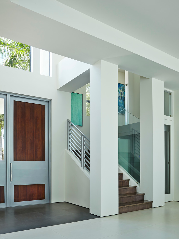 Cette image montre une porte d'entrée design de taille moyenne avec un mur blanc, sol en béton ciré, une porte simple et une porte en bois foncé.