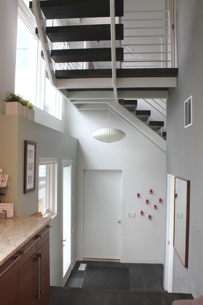 Inspiration pour une entrée design avec un couloir, un mur gris, une porte simple et une porte en verre.