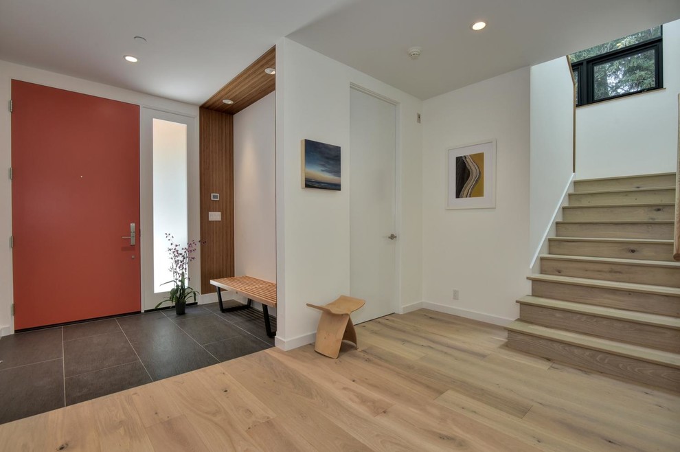 Mid-sized trendy light wood floor entryway photo in San Francisco with white walls and an orange front door