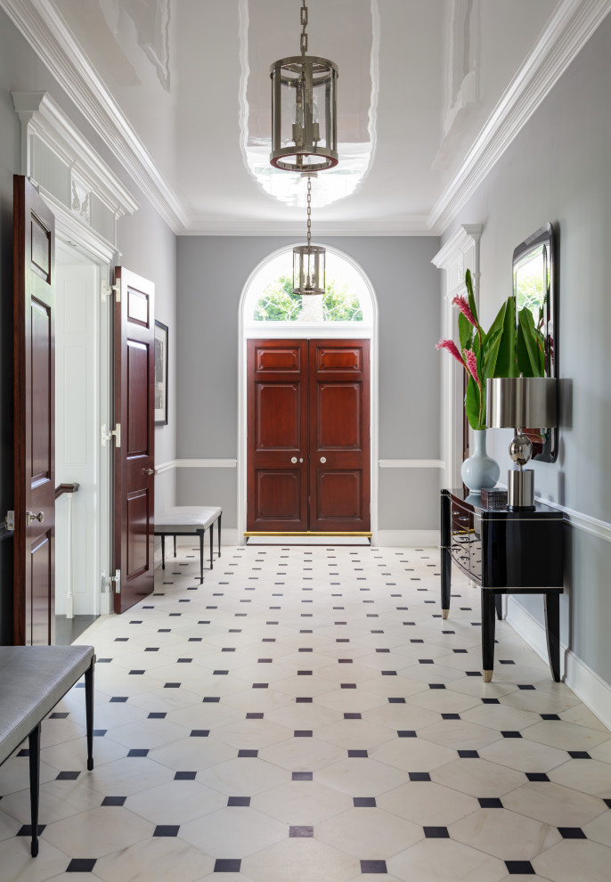На фото: большая узкая прихожая в стиле неоклассика (современная классика) с серыми стенами, полом из керамогранита, двустворчатой входной дверью, входной дверью из дерева среднего тона и разноцветным полом