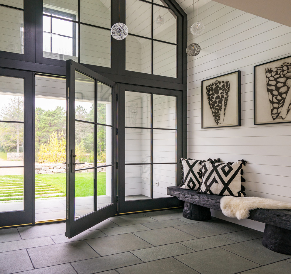 На фото: фойе в морском стиле с белыми стенами, одностворчатой входной дверью, стеклянной входной дверью и серым полом с