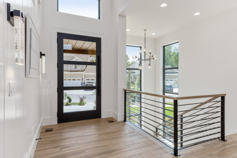 This is an example of a large contemporary foyer in Salt Lake City with white walls, porcelain flooring, a single front door, a black front door and beige floors.