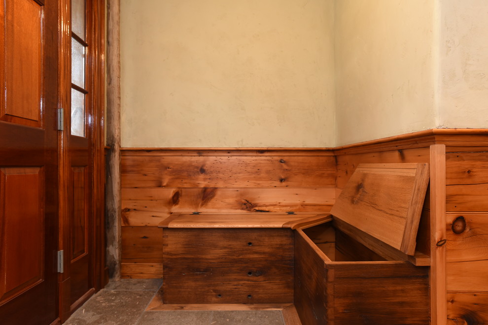 Großer Uriger Eingang mit Stauraum, beiger Wandfarbe, hellem Holzboden, Einzeltür, dunkler Holzhaustür und braunem Boden in Orange County