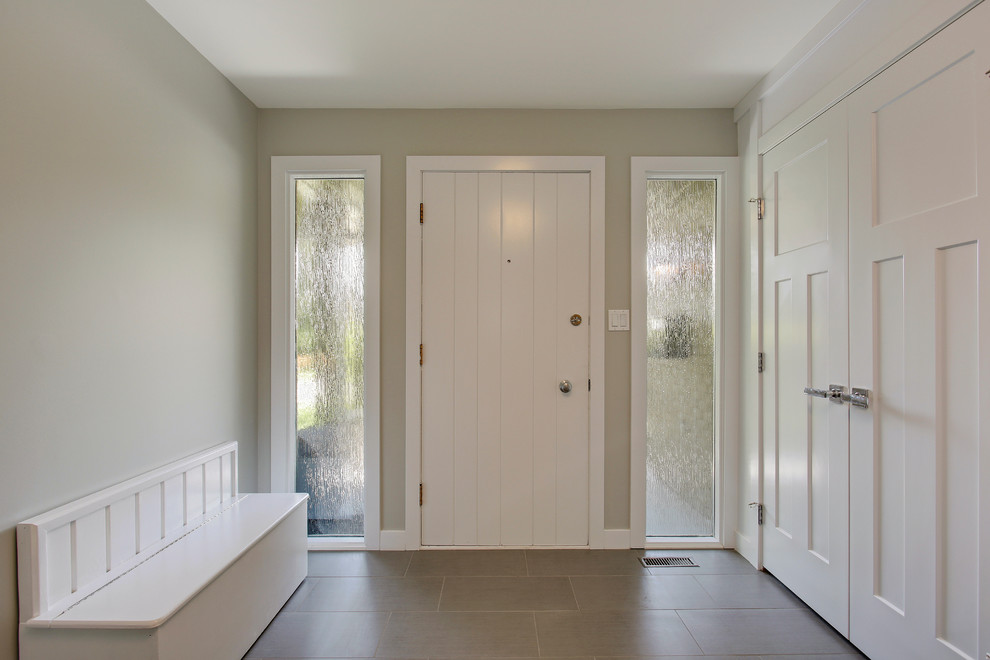 На фото: входная дверь среднего размера в стиле неоклассика (современная классика) с бежевыми стенами, полом из керамогранита, одностворчатой входной дверью и белой входной дверью