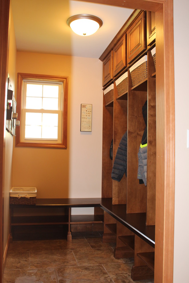 Medium sized classic boot room in Chicago with brown walls, ceramic flooring and brown floors.
