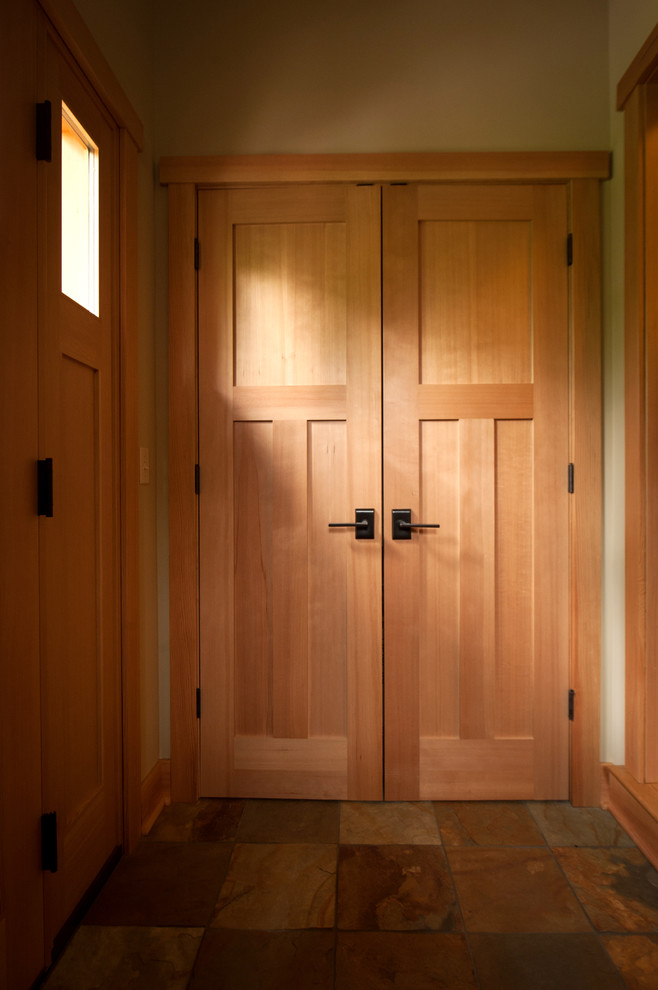 Diseño de distribuidor de estilo americano de tamaño medio con paredes beige, suelo de pizarra, puerta simple y puerta de madera clara