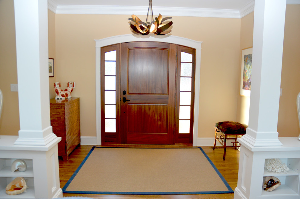 ポートランド(メイン)にある小さなコンテンポラリースタイルのおしゃれな玄関ドア (ベージュの壁、ラミネートの床、濃色木目調のドア、茶色い床) の写真