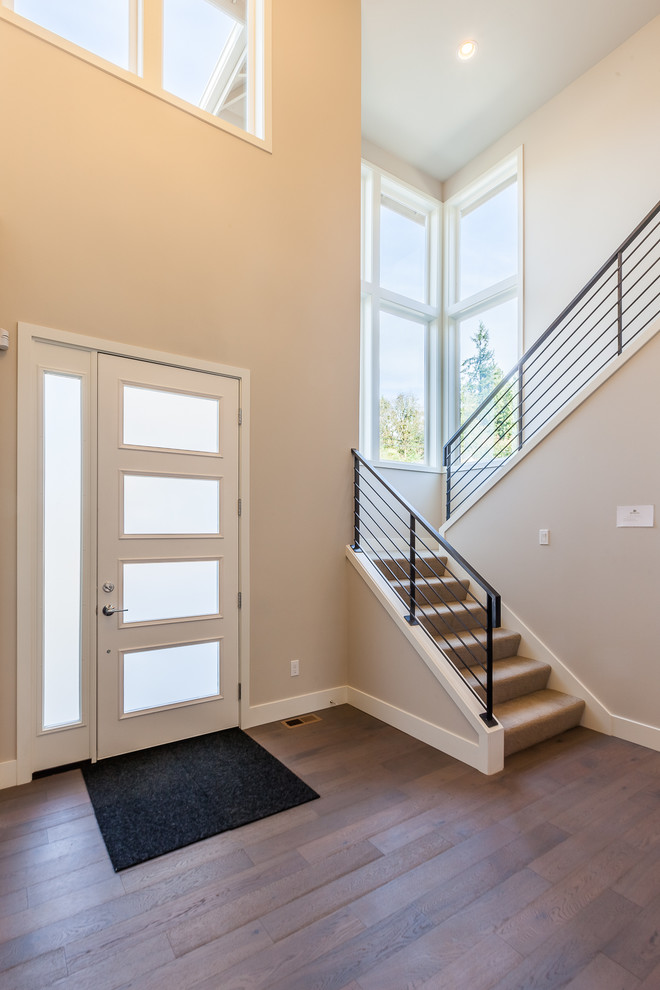 Idee per un ingresso moderno di medie dimensioni con pareti beige, parquet scuro, una porta singola e una porta bianca