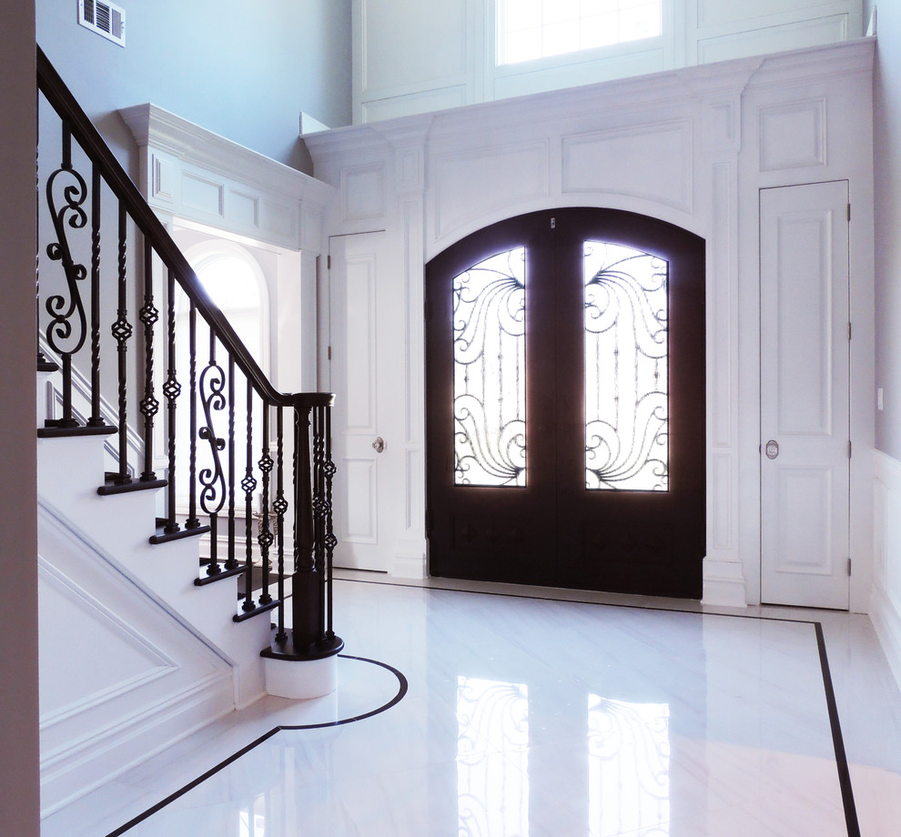 Großes Klassisches Foyer mit grauer Wandfarbe, Marmorboden, Doppeltür, dunkler Holzhaustür und weißem Boden in New York