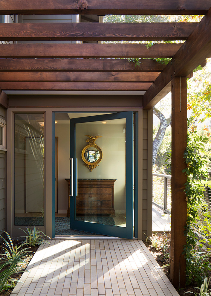Пример оригинального дизайна: входная дверь в современном стиле с поворотной входной дверью, полом из керамической плитки и синей входной дверью