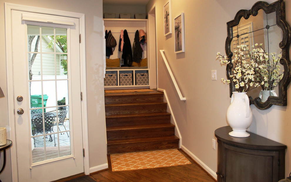 Idée de décoration pour une petite entrée tradition avec un vestiaire, un sol en bois brun et une porte simple.