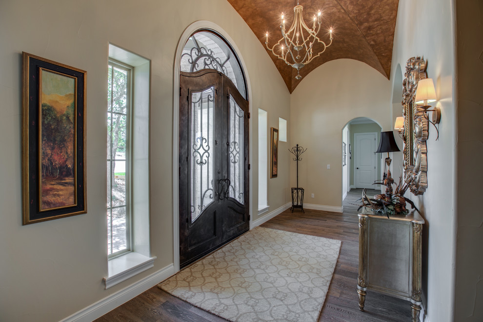 Inspiration for a mid-sized mediterranean medium tone wood floor and brown floor entryway remodel in Austin with beige walls and a black front door