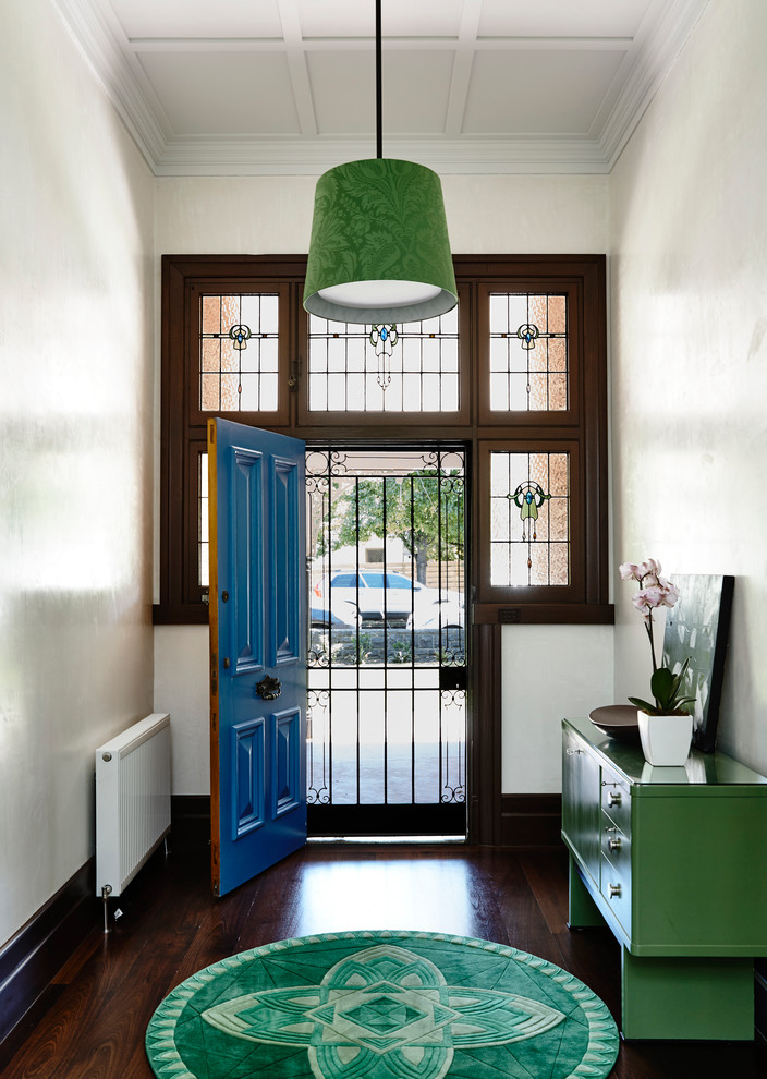 Aménagement d'une grande porte d'entrée contemporaine avec un mur blanc, parquet foncé, une porte simple et une porte bleue.