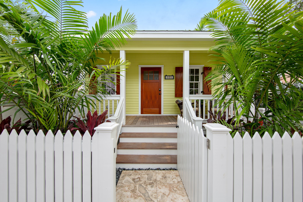 マイアミにあるトロピカルスタイルのおしゃれな玄関ドア (緑の壁、無垢フローリング、木目調のドア、茶色い床) の写真