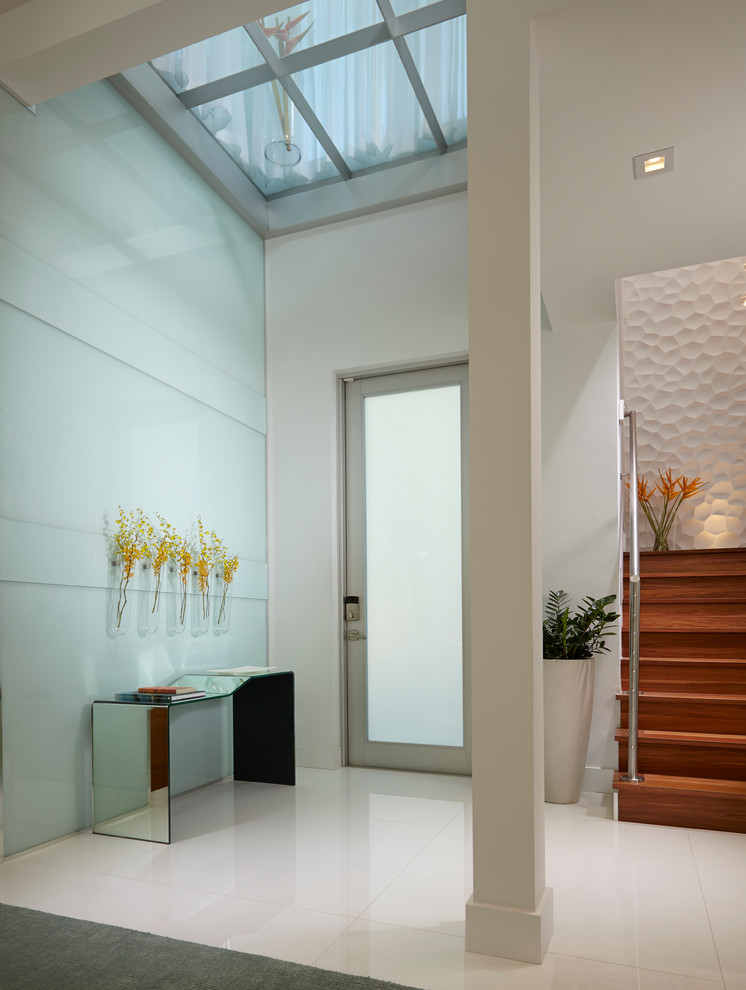 Inspiration for a mid-sized contemporary marble floor entryway remodel in Miami with white walls and a glass front door