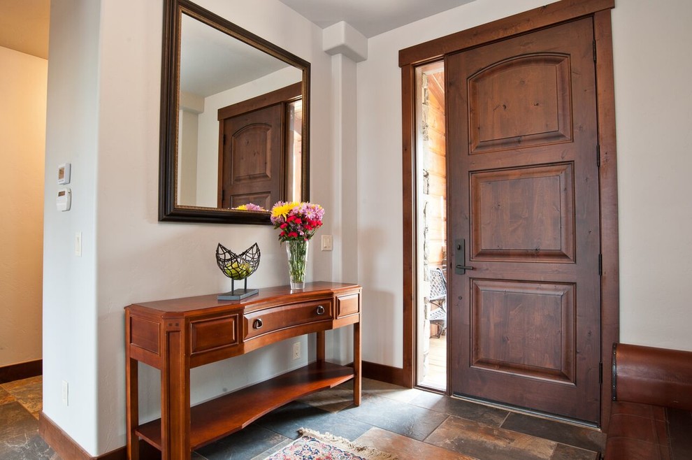 Пример оригинального дизайна: фойе среднего размера в стиле рустика с полом из сланца, одностворчатой входной дверью и входной дверью из темного дерева