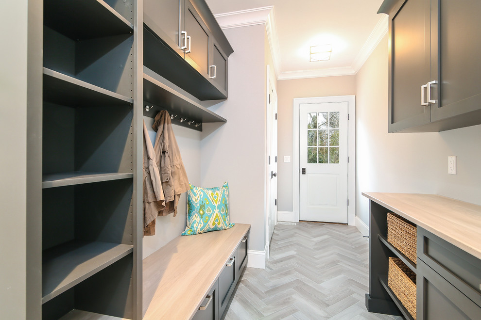 Example of a mid-sized transitional porcelain tile mudroom design in New York with beige walls
